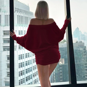 Détail de la mini-robe rouge à épaules dénudées avec manches longues et fronces latérales
