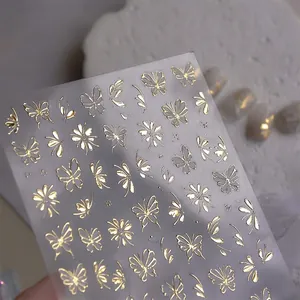 Golden butterfly nail stickers with metallic foil snowflakes and floral patterns