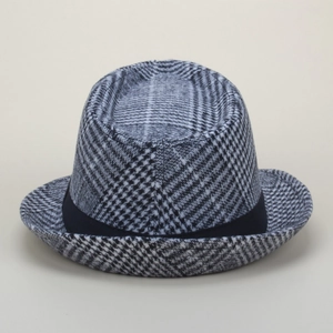 Dettaglio di un cappello fedora in lana a quadri stile britannico con fascia nera.