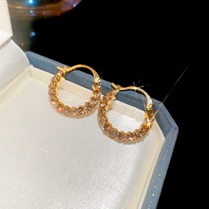 Makroaufnahme von 18k vergoldeten Creolen mit bernsteinfarbenen Kristallen in Box