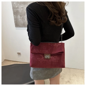 Detail view of burgundy corduroy shoulder bag with traditional Chinese floral embossing
