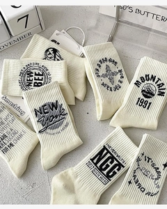 Flat lay of vintage cotton crew socks with various retro graphic prints on grey surface