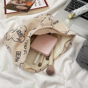 Detail of corduroy makeup bag with cute bear print showing interior storage capacity