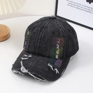 Macro detail of distressed black denim baseball cap with colorful rainbow embroidery