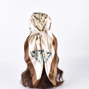 Detailed close-up of floral satin square scarf with butterfly print and brown border