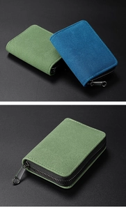 Close-up of green and blue suede card holders with black zippers and textured finish