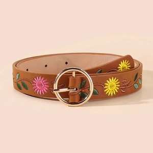 Detailed embroidery of colorful flowers on brown leather belt with golden metal buckle