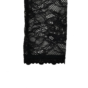 Close-up of black floral lace fabric with intricate patterns and scalloped edge detail