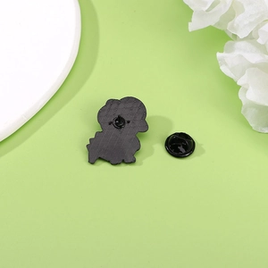 Back view of cute dinosaur metal badge with black butterfly clutch and sharp pin
