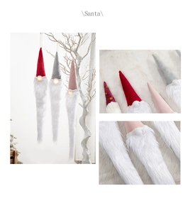 Detail of plush Santa gnomes hanging from branches in red, grey, and pink festive tones