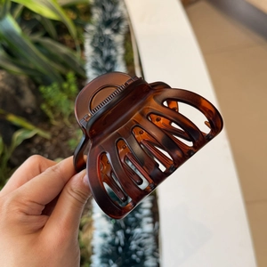 Close-up of a large brown tortoiseshell hair claw clip with a hollow resin design