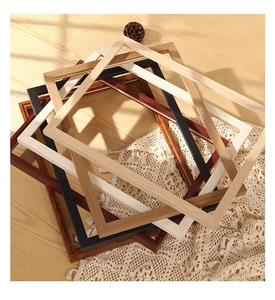Close-up of stacked vintage solid wood frames in black, white, and natural wood tones