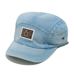 Close-up of light blue denim five-panel camper hat featuring a brown leather patch with ring