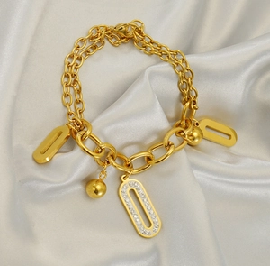 Détail du bracelet double chaîne en acier 18K avec pendentifs ovales et diamants