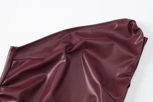 Close-up of premium burgundy PU leather texture with detailed reinforced stitching