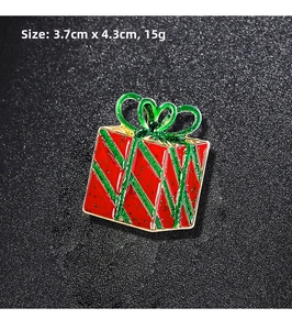 Macro shot of 3.7cm Santa gift box brooch with red green oil drop and gold finish