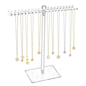 Close-up of clear acrylic necklace organizer with multi-hook design on white background