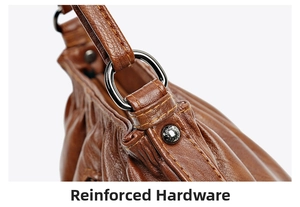 Detail view of the brown leather pleat bag showing reinforced hardware and rivets