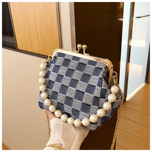 Detail of denim checkerboard clutch bag with pearl chain and gold metal frame