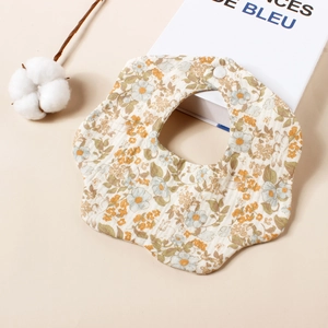 Detail van een baby slabbetje van katoenen mousseline met bloemenprint en knopje.