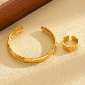 Golden stainless steel jewelry set featuring evil eye engravings on ring and bracelet