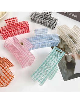 Flat lay of colorful acrylic hair claws in assorted plaid patterns on a white backdrop