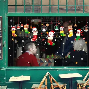 Christmas window decals with Santa and reindeer on a warm glowing shop glass front