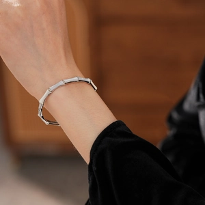 Detail of silver bamboo style bracelet with mother of pearl on a woman wrist