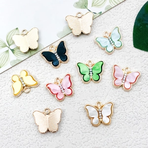 Gros plan de pendentifs papillons colorés en émail et plaqué or pour bijoux DIY