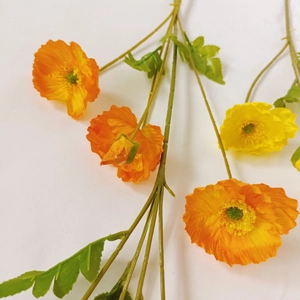 Top view of realistic orange and yellow artificial poppy flowers with green stems