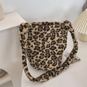 Detail of plush leopard print faux fur bucket bag with magnetic closure and wide strap