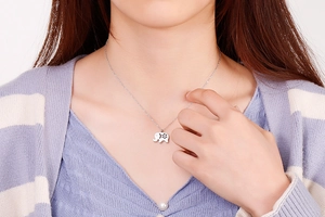 Detailed close-up of cute hollow elephant pendant on a thin stainless steel chain