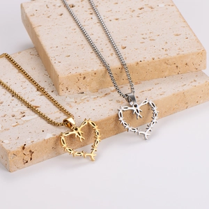 Hip hop punk thorn heart necklaces in gold and silver finish on stone display