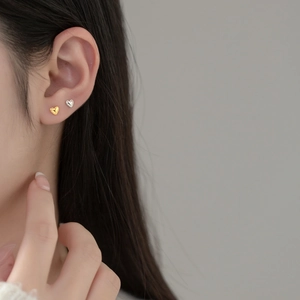 Minimalist S925 sterling silver heart stud earrings in gold and silver finish on model