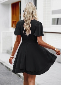 Vue arrière d'une robe courte noire à manches courtes avec jupe à volants et lien