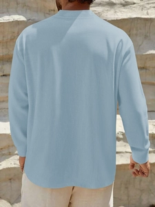 Rear view of a light blue linen short sleeve shirt with textured fabric on model outdoors