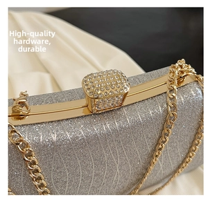 Close-up of gold metal frame and sparkling crystal clasp on silver sequin evening bag