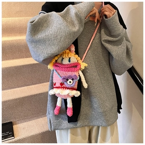 Pink handmade crochet crossbody bag with cute doll face and purple monster detail