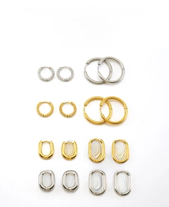 Detailed macro view of gold and silver hoop earrings in round and oval geometric shapes
