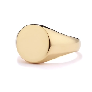 Close-up of polished gold circular signet ring with a smooth flat surface for engraving