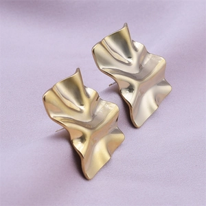 Macro shot of 18k gold plated stainless steel stud earrings with irregular folded texture