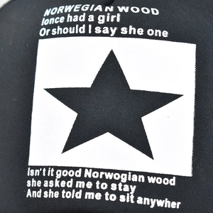 Detail of black mesh cap featuring a white square print with star and lyric typography