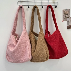 Plush teddy fleece tote bags in pink, brown and red hanging on display hooks