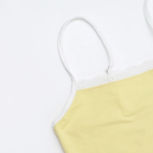 Dettaglio del top giallo con bordo in pizzo bianco delicato e spalline sottili rego