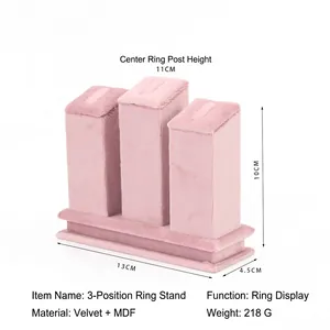 Close-up of pink velvet jewelry display stand with three rings holders at various heights