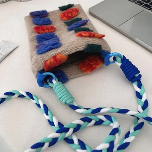 Detailed macro shot of vintage wool felt mini crossbody bag with colorful plush accents