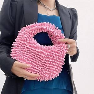 Close-up of pink fluffy plush handbag with soft mop-style texture and round handle