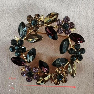 Detailed size and weight view of a golden wreath brooch with colorful crystals