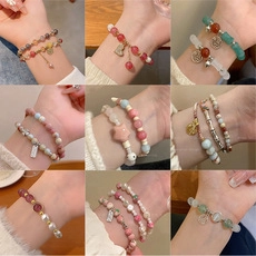 Detailed grid view of assorted vintage pearl and beaded bracelets with heart charms