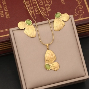 Golden necklace and earrings set with butterfly wings and green cat eye stones